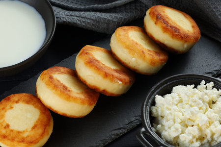 curd fritters with milk and cottage cheese. Food photo in a dark tone.の写真素材