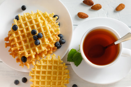 Belgian waffles with tea and berries. Traditional Belgian waffles with blueberriesの写真素材