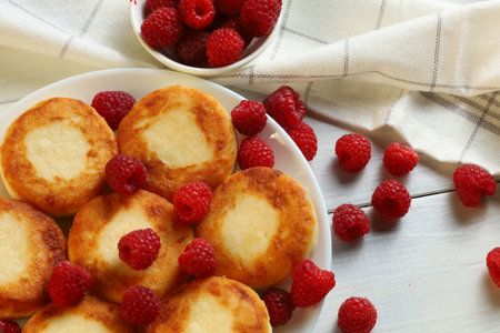 curd fritters with raspberries Traditional breakfast. Food on a bright table.の写真素材