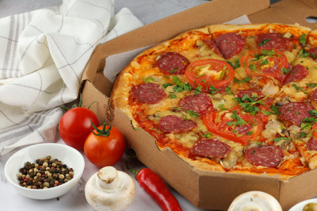 Pizza in a box on the table. Hot pizza with vegetables. Pizza in a restaurant.の写真素材