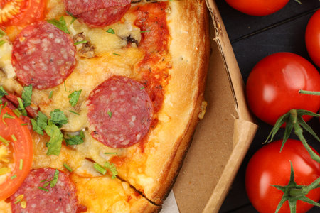 Pizza in a box on the table. Hot pizza with vegetables. Pizza in a restaurant.の写真素材