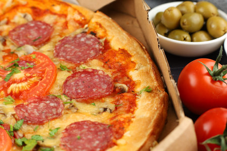 Pizza in a box on the table. Hot pizza with vegetables. Pizza in a restaurant.の写真素材
