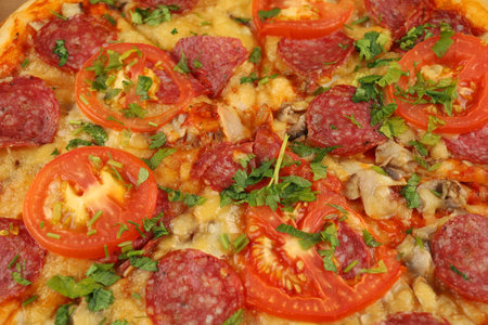 Pizza with sausage, tomatoes and cheese close-up.の写真素材