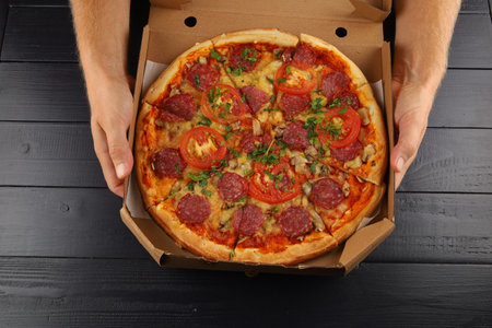 pizza box open. Pizza in the delivery box against a dark backgroundの写真素材