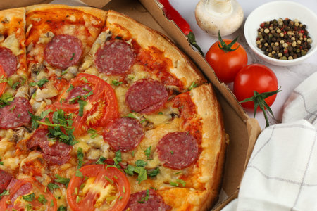 Pizza in a box on the table. Hot pizza with vegetables. Pizza in a restaurant.の写真素材