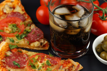 Pizza and cola with ice. Tasty and hearty pizza meal and soft drink.の写真素材