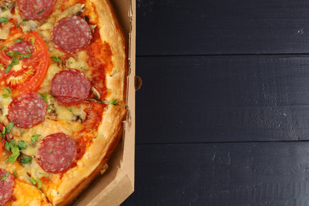 Pizza with salami and tomatoes in a box. place for text cope spaceの写真素材