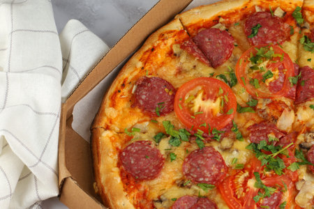 Pizza in a box on the table. Hot pizza with vegetables. Pizza in a restaurant.の写真素材