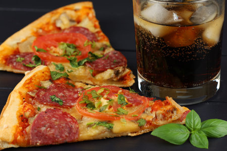 Pizza and cola with ice. Pizza with cola on the table in the restaurant.の写真素材