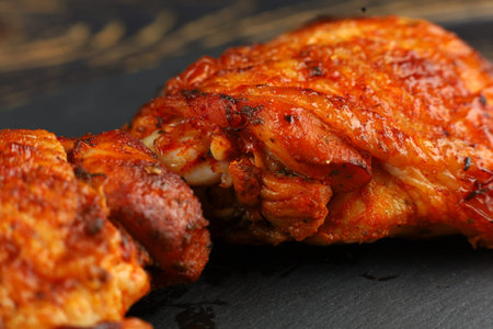 chicken thighs Baked. Grilled chicken thighs on plate over dark stoneの写真素材
