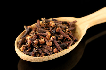 Clove spice in a wooden spoon. A spice of dried cloves lies on a wooden spoonの写真素材