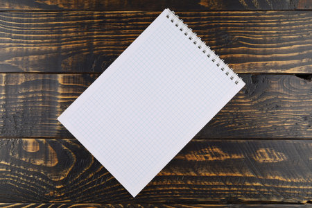 Notebook with cells on a wooden background. empty notebook on wooden table, top viewの写真素材