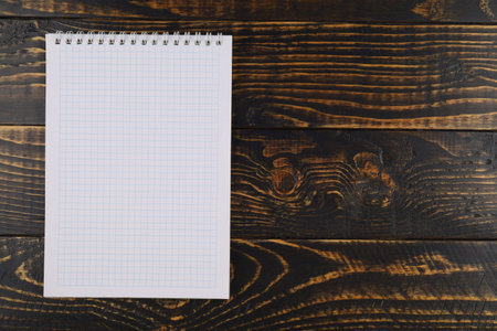 Notebook with cells on a wooden background. empty notebook on wooden table, top viewの写真素材