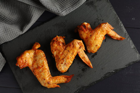 Bbq buffalo wings. Fried chicken on a dark background. delicious grilled chicken wingsの写真素材