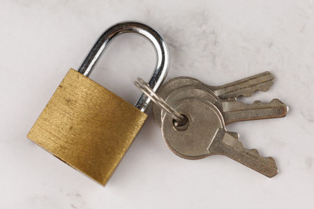 Small lock with keys. Locked Golden Padlock on the white backgroundの写真素材