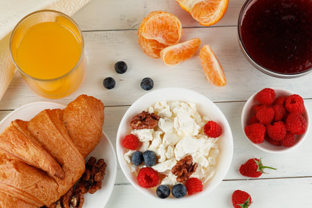 Breakfast with cheese and croissant. breakfast table with cheese, berries and croissant. top view of breakfastの写真素材