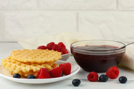 Belgian waffles with raspberry jam. Belgian waffles with berriesの写真素材