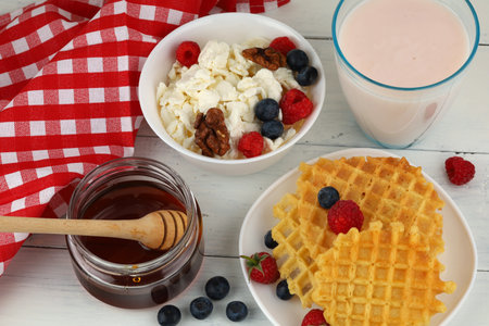 Delicious food with waffles, honey and homemade cheese with berriesの写真素材