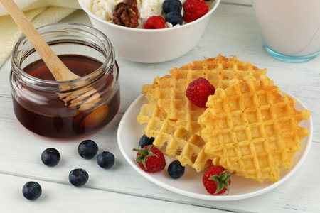 Waffles with honey and berries for breakfastの写真素材