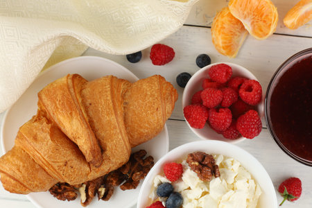 Breakfast with cheese and croissant. breakfast table with cheese, berries and croissant. top view of breakfastの写真素材