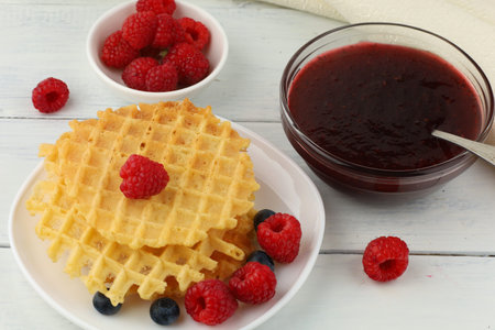 Belgian waffles with raspberry jam. Belgian waffles with berriesの写真素材