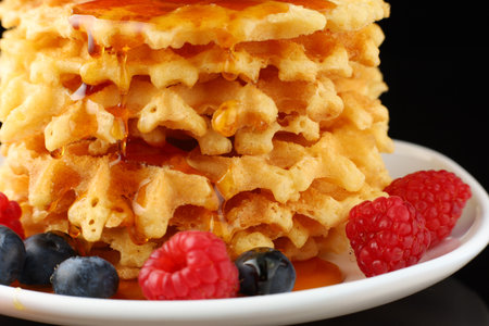 Belgian waffles with honey and berriesの写真素材
