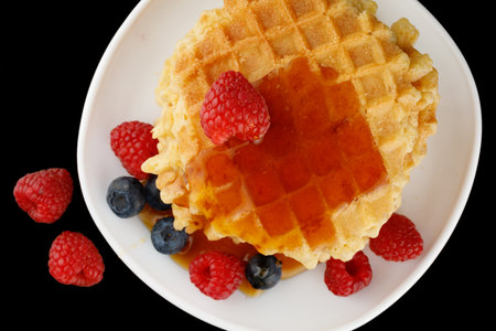 Belgian waffles with honey and berriesの写真素材