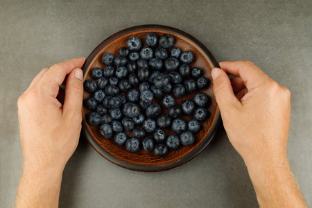 blueberry in a plate in handsの写真素材