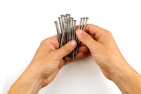 Hands holding nails. Construction nails in hand isolate.の写真素材