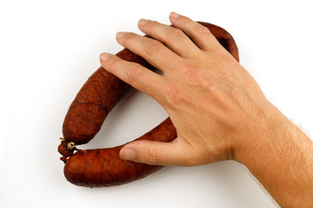 Hand takes sausage isolate. Sausage ringの写真素材