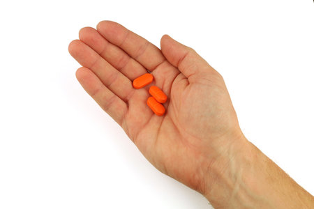 Orange pills in hand isolateの写真素材
