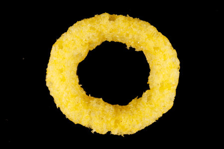 Corn rings. Yellow snacks on a black backgroundの写真素材