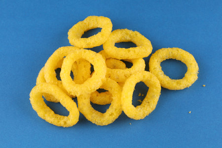 Corn rings. Yellow snacks blue backgroundの写真素材