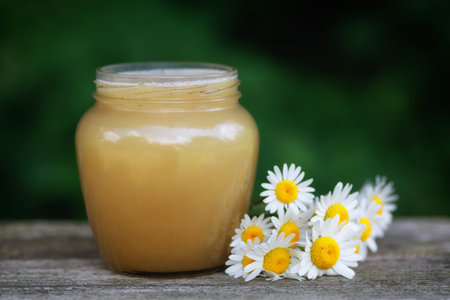 Honey in a jar on the pass. Jar of honey with flowersの写真素材