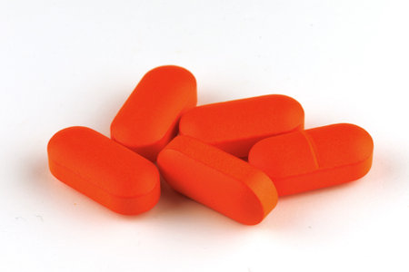 Orange oblong tablet isolated on whiteの写真素材