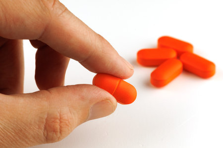 Orange oblong tablet in handの写真素材