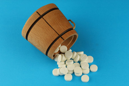 White medical round pills in a wooden barrelの写真素材