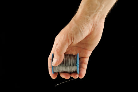 Coil of thin steel iron wire in handの写真素材