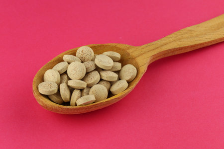 Brewer's yeast in tablets in a wooden spoonの写真素材