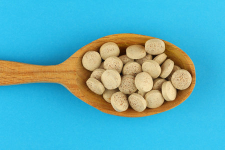 Brewer's yeast in tablets in a wooden spoonの写真素材