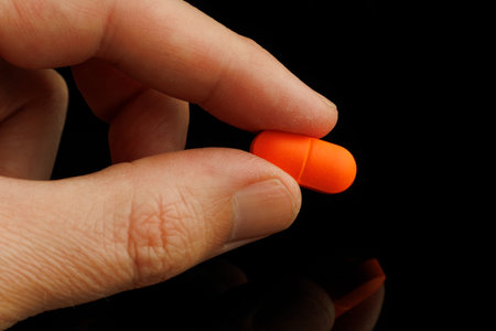 Orange oblong tablet in handの写真素材