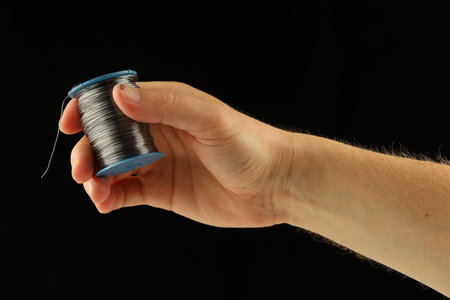 Coil of thin steel iron wire in handの写真素材