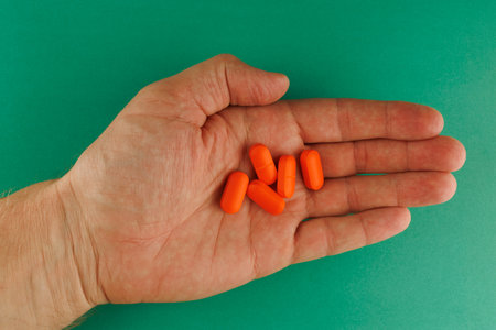 Orange oblong tablet in the palmの写真素材