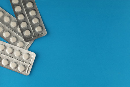 Pills in a blister on blue background. place for text cope spaceの写真素材