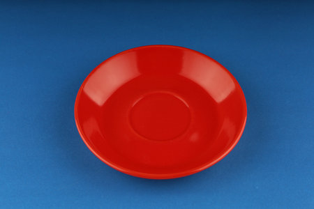 Red empty plate on a blue backgroundの写真素材