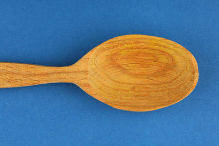 Wooden empty spoon on a blue backgroundの写真素材