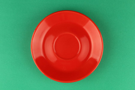Red empty plate on a green background. minimalismの写真素材