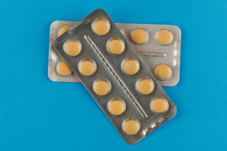 Orange pills in a blister on a blue backgroundの写真素材