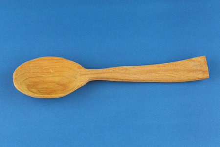 Wooden empty spoon on a blue backgroundの写真素材