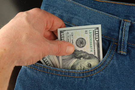 Hand takes money dollars from pocketの写真素材